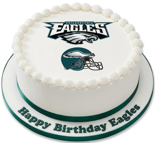 Round white cake with Philadelphia Eagles logo and helmet, green ribbon, and white piped icing.