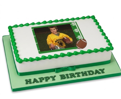 Rectangular white cake with green piped border, featuring an edible photo of a child on a football pitch, with a football illustration and 'Happy Birthday' on the board.