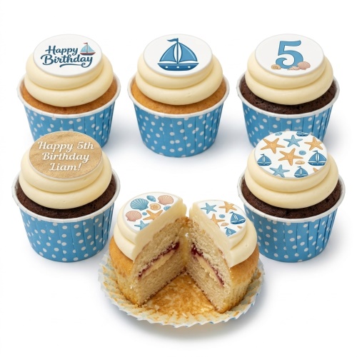 Nautical theme cupcakes with sailboats, starfish, and seashells on white icing with blue polka dot wrappers.