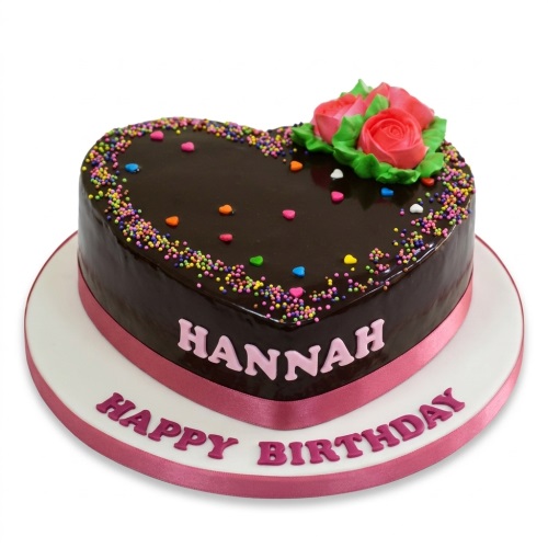 Heart shaped chocolate birthday cake with pink roses, green leaves, and colourful sprinkles, with space for a custom name and message.