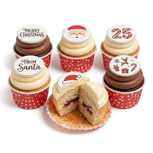 A selection of Christmas cupcakes with Santa, reindeer, 'Merry Christmas', 'From Santa', and '25' toppers on red polka dot cases.