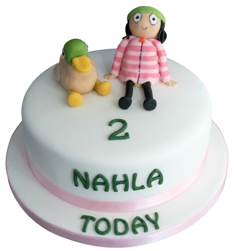 White round kids birthday cake with a girl and duck figure, custom age number, and personalised name.