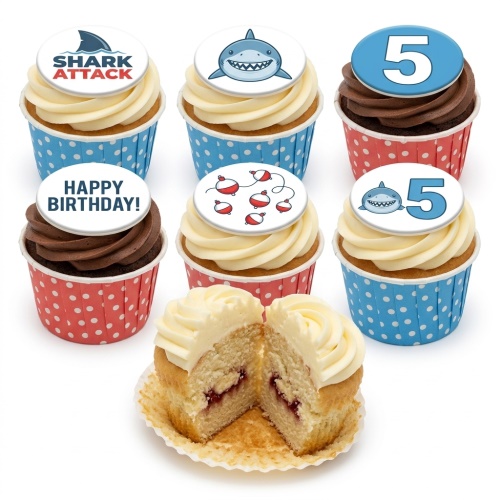A set of shark-themed birthday cupcakes with vanilla and chocolate frosting, featuring custom age and 'Happy Birthday!' toppers.