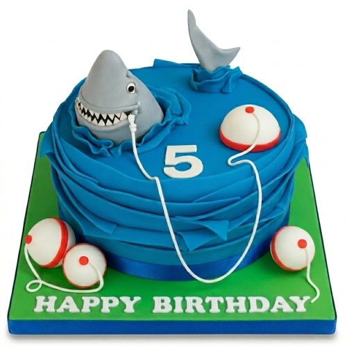 Round blue birthday cake with 3D grey shark, fin, fishing line, bobbers, and custom age topper.