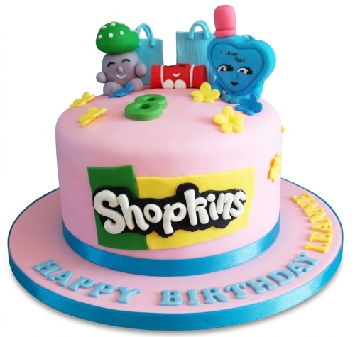 Pink single-tier Shopkins birthday cake with 3D characters, shopping bags, and custom age topper.