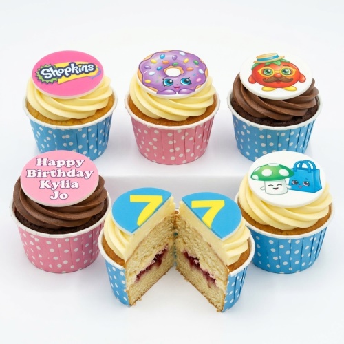 Assortment of Shopkins themed cupcakes with various character toppers, including a custom age topper and a personalised message example.