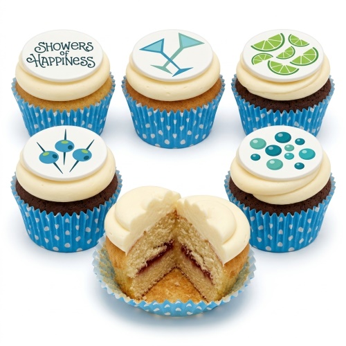Assortment of cupcakes with white frosting, blue polka dot wrappers, and cocktail-themed toppers including glasses, limes, blueberries, and bubbles.