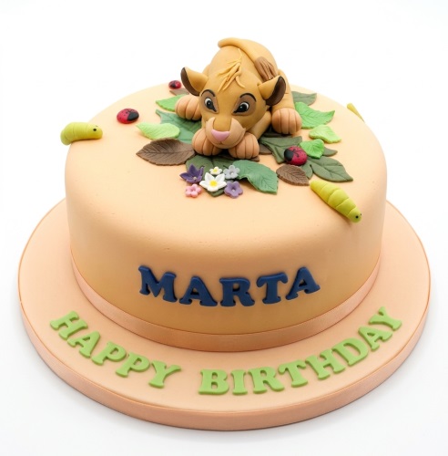 Round peach cake with 3D Simba topper, green leaves, red ladybugs, and yellow caterpillars.