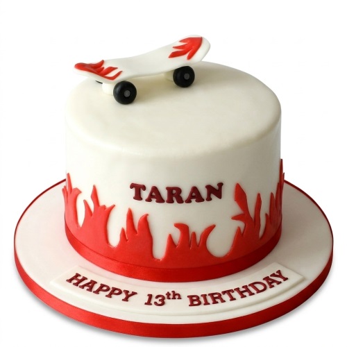 White round birthday cake with a 3D skateboard topper and red flame decorations.