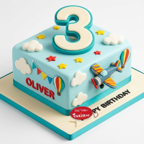 Light blue square birthday cake with custom age topper, aeroplane, hot air balloons, clouds, and stars.