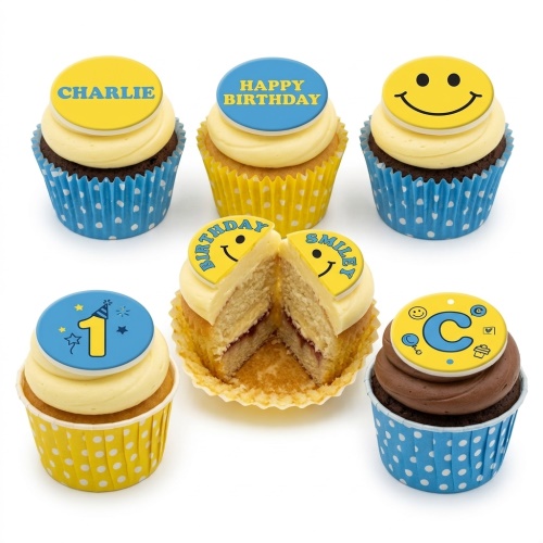 Assortment of yellow and blue smiley face birthday cupcakes with custom age and initial toppers.