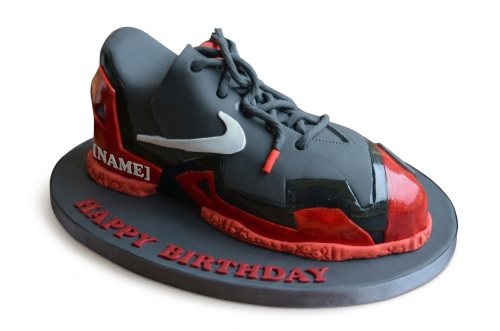 3D sculpted Nike-style trainer birthday cake in grey and red with white swoosh and laces.
