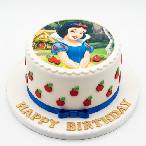 Round white cake with Snow White edible image, red apple decorations, and blue ribbon.