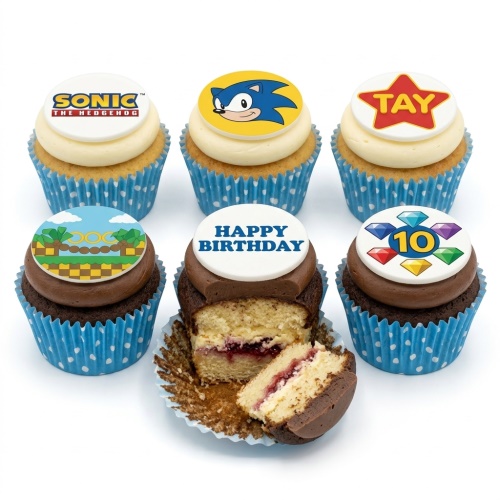 Six Sonic the Hedgehog themed cupcakes with edible toppers, including Sonic logo, character, game landscape, Chaos Emeralds with custom age, and 'Happy Birthday' message.