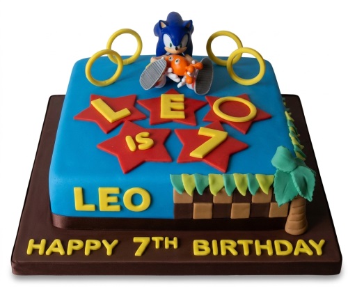 Blue square Sonic the Hedgehog birthday cake with Sonic and Tails figures, gold rings, and custom age.