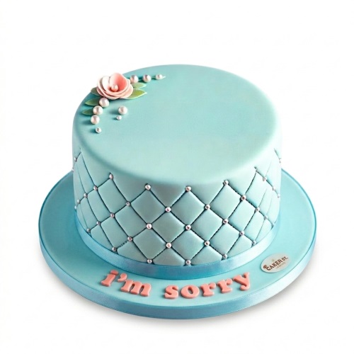 Elegant aqua quilted cake with a pink sugar flower, white pearls, and a custom message.