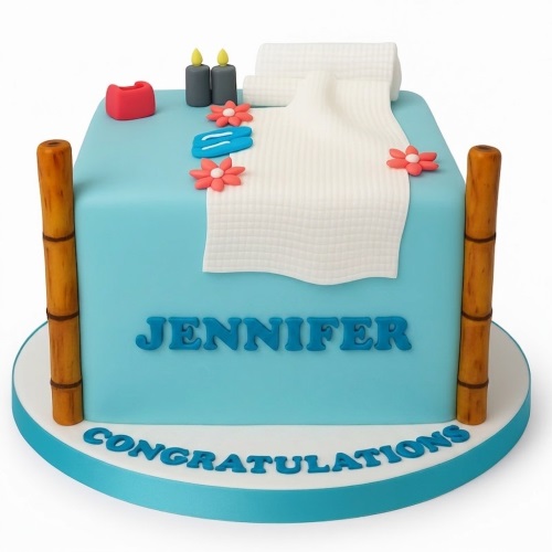 Light blue spa theme cake with white towels, candles, slippers, and flowers, featuring a custom name and message.