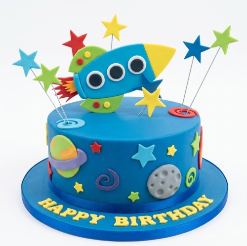 Blue space-themed birthday cake with a rocket, planets, stars, and 'Happy Birthday' message.