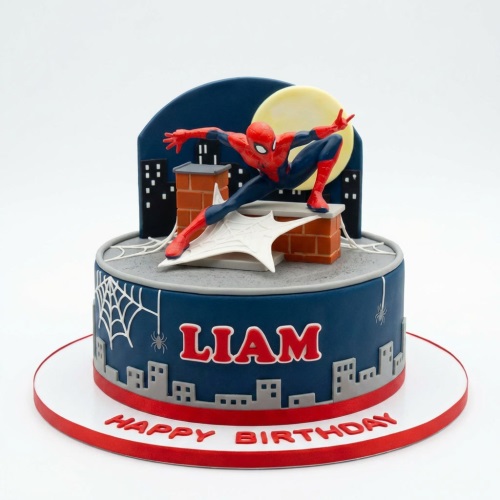 Two-tier Spiderman birthday cake with figurine, city skyline, spiderwebs, and custom name.