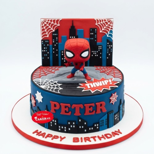 Two-tier Spiderman birthday cake with Funko Pop figure, city skyline, and spider webs.