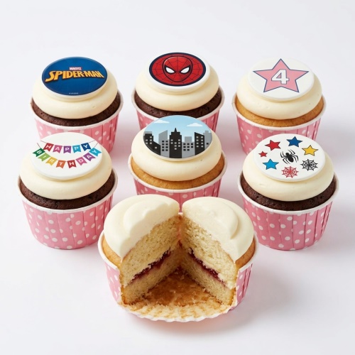 Spiderman themed birthday cupcakes with white frosting, red and blue superhero toppers, cityscape, stars, and a custom age topper.