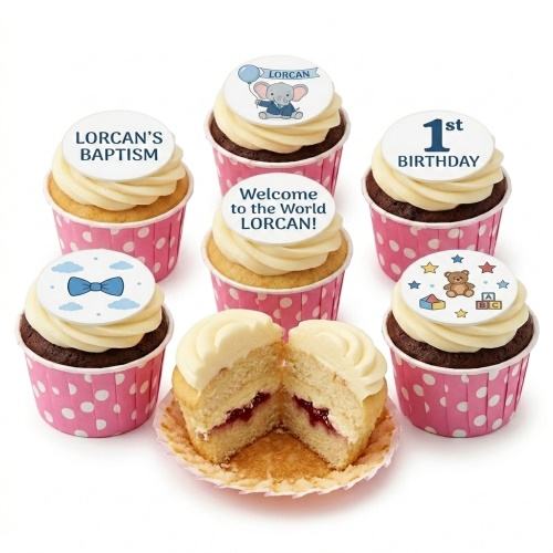 Cupcakes with white frosting and baby-themed toppers, including a 1st birthday, elephant, bow tie, and teddy bear.