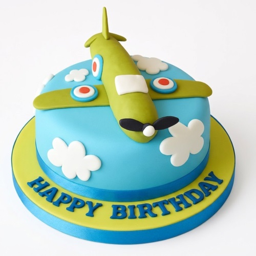 Round blue and green aeroplane birthday cake with a 3D plane topper and white clouds.