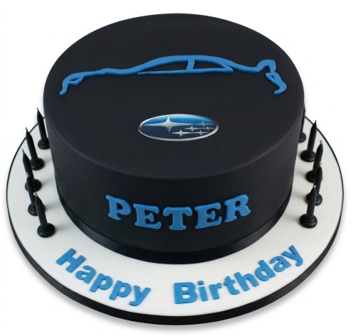 Black round birthday cake with blue Subaru car silhouette and logo, personalised name, and 'Happy Birthday' message.