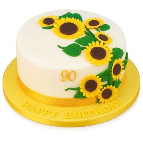 Round white birthday cake with edible yellow sunflowers, green leaves, and a gold custom age '90'.