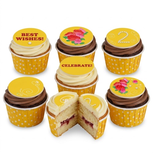 Six cupcakes with yellow polka dot wrappers, some with white and some with chocolate frosting. Toppers include floral designs, "Best Wishes!", "Celebrate!", and a custom age "2" in pearls.
