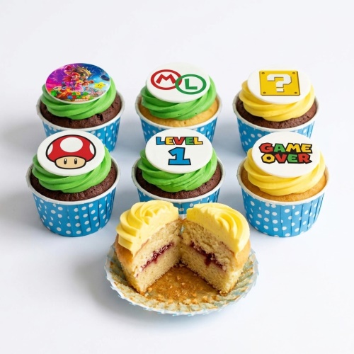 Super Mario themed cupcakes with green and yellow frosting, featuring Mario, Luigi, mushroom, question block, Level 1, and Game Over toppers.