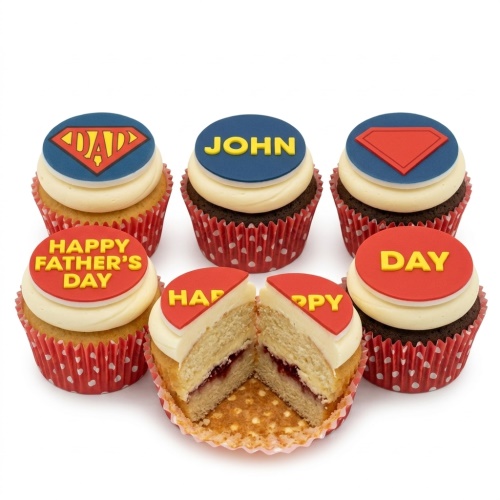 Six cupcakes with red and blue superhero shield toppers, some personalised for Father's Day.