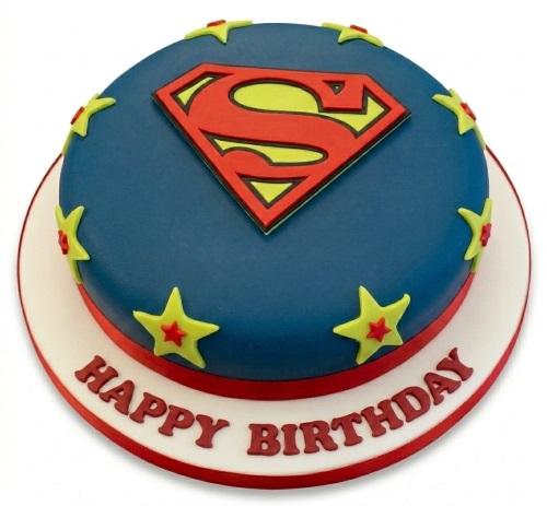 Round blue fondant cake with a red and yellow Superman logo and yellow stars, with "Happy Birthday" written on the board.