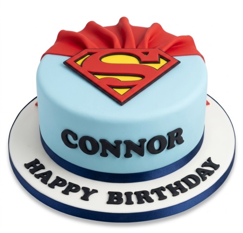 Round blue Superman themed birthday cake with red cape, yellow and red 'S' logo, and a dark blue ribbon.