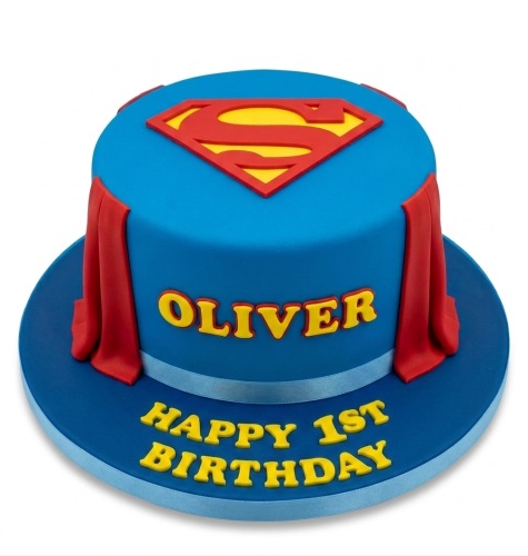 Round blue Superman birthday cake with red 'S' logo and draped red cape, featuring personalised name and birthday message.