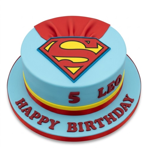 Round blue fondant cake with a red and yellow Superman logo and a red cape on top, with red and yellow stripes around the base.