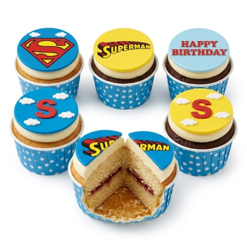 Collection of Superman themed cupcakes with blue and yellow toppers, featuring the Superman logo, 'SUPERMAN' text, and a red 'S' with clouds.