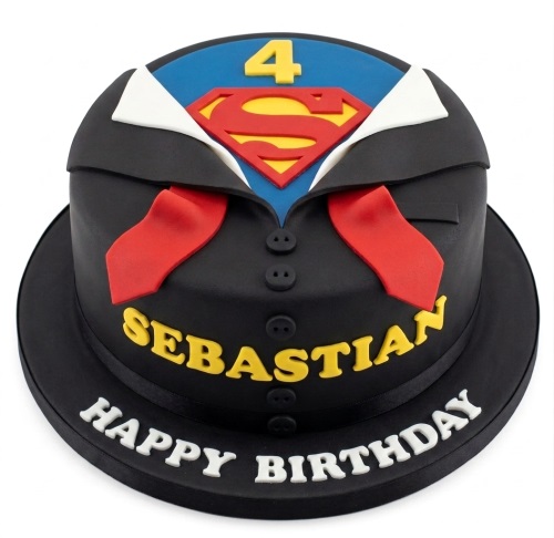 Round black cake designed as a suit revealing a red and yellow Superman logo with a custom age topper and name.