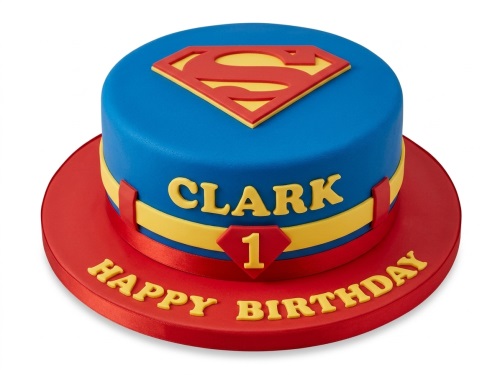 Round blue and red Superman birthday cake with yellow 'S' shield, personalised name, and custom age.
