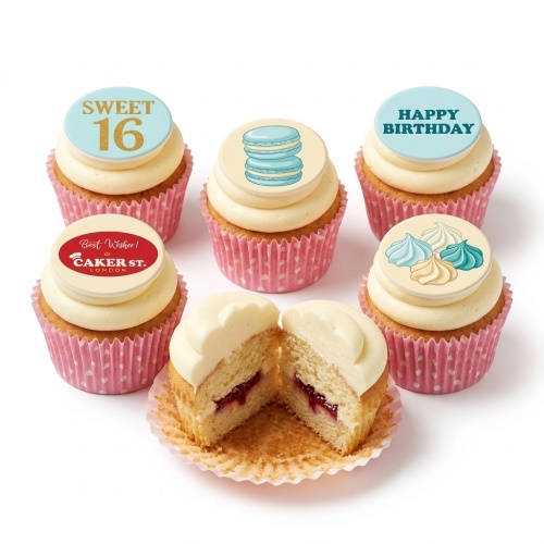 Assortment of elegant birthday cupcakes with pastel frosting, custom age topper, macarons, and meringues.