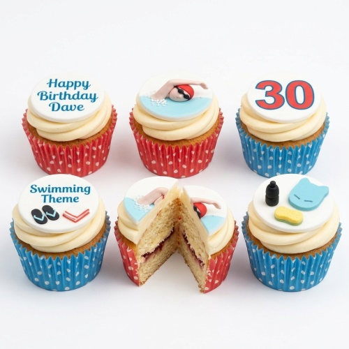 Assortment of swimming theme birthday cupcakes with custom age topper and various aquatic decorations.