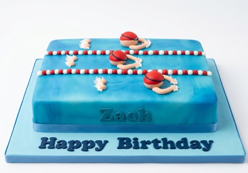 Blue swimming pool birthday cake with fondant swimmers, lane ropes, and a custom message.