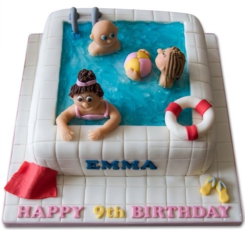 Rectangular swimming pool themed birthday cake with fondant figurines, beach ball, and lifebuoy.