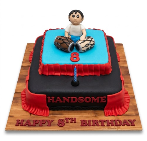 Two-tiered black and blue birthday cake with a boy figure, Dholak drums, and custom age '8' topper.