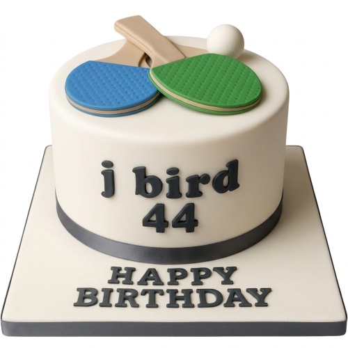 Round white cake decorated with blue and green table tennis bats, a white ball, and a custom message.