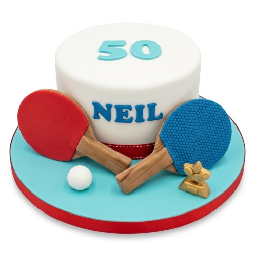 White round cake with red and blue table tennis paddles, ball, and gold trophy.