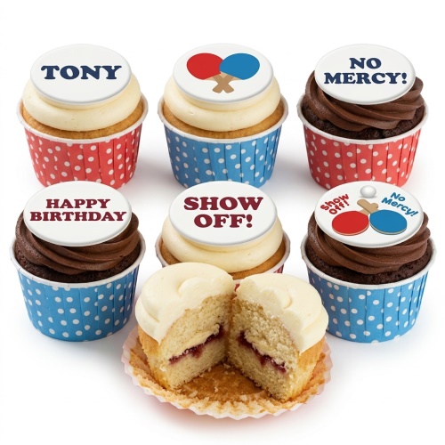 A selection of vanilla and chocolate cupcakes with white frosting and edible table tennis themed toppers in red and blue polka dot wrappers.