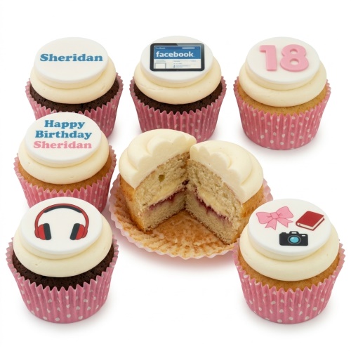 Assorted birthday cupcakes with custom age and hobby-themed edible toppers, including headphones, social media, camera, and book designs.