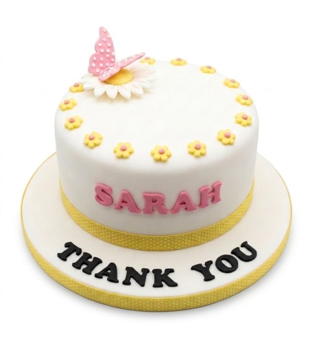 White round cake with pink butterfly, white daisy, yellow flowers, yellow ribbon, and space for personalised name.