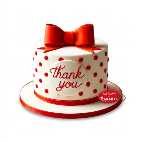 White round cake with red polka dots, a large red bow on top, and a 'thank you' message plaque.